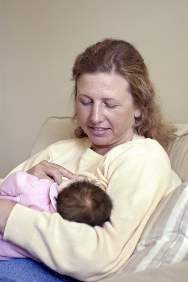 Woman nursing baby daughter