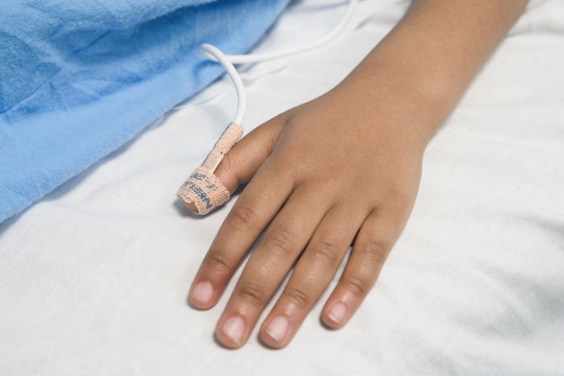 Close up of African child's hand with IV on hospital bed