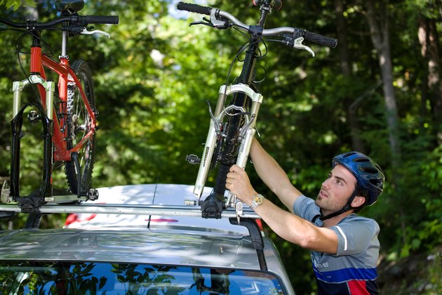 Man fastening bikes on car rack