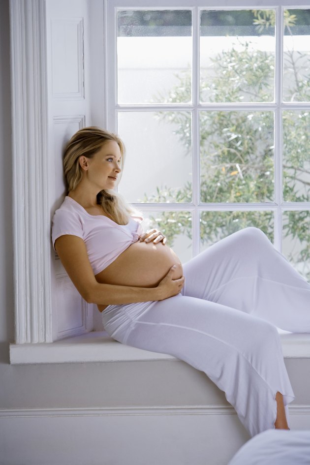 Pregnant woman sitting by window