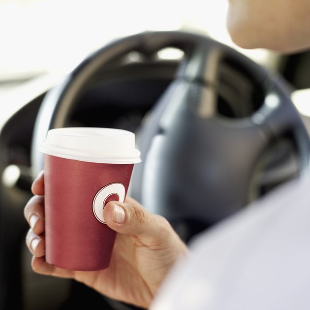 man holding a cup in a car