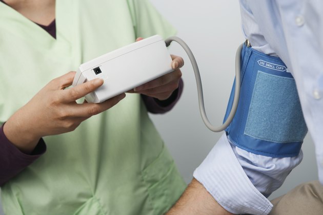 Doctor checking patients blood pressure,close-up