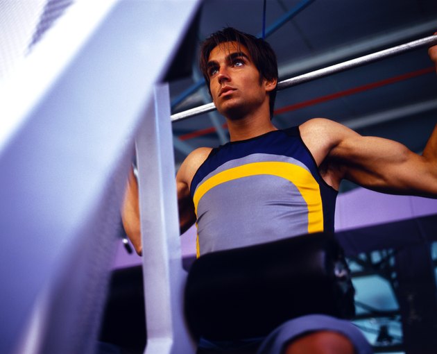 Low angle view of a young man lifting weights