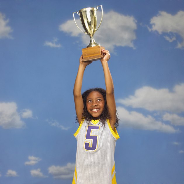 Basketball player holding trophy overhead