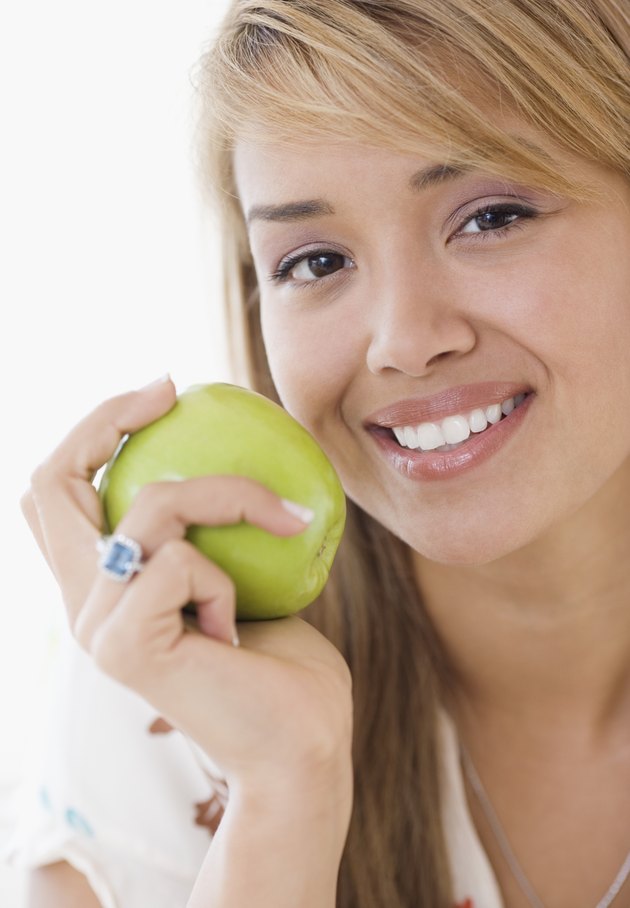 Hispanic woman eating apple