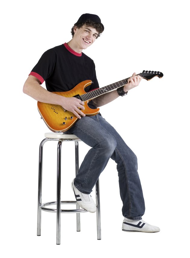 Teenage musician sitting on stool