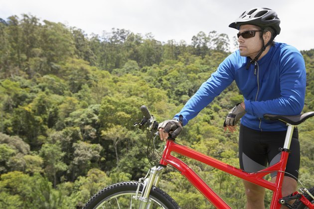 Male cyclist leaning on mountain bike