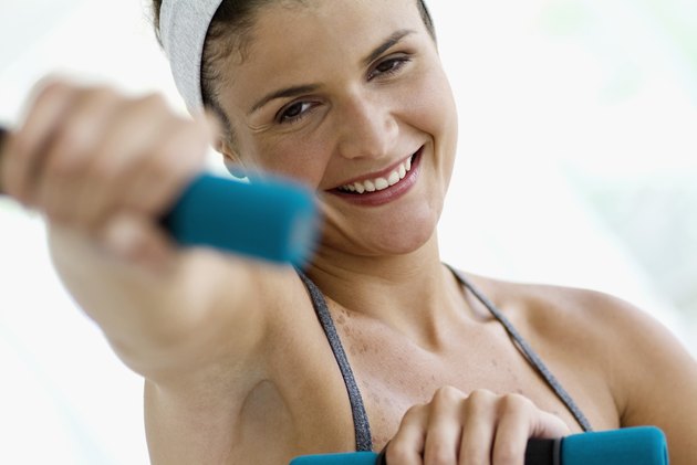Young woman using hand weight, close-up, selective focus