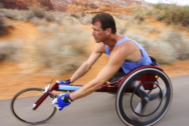shot of a male caucasian wheelchair racer as he trains in a rural red rock setting