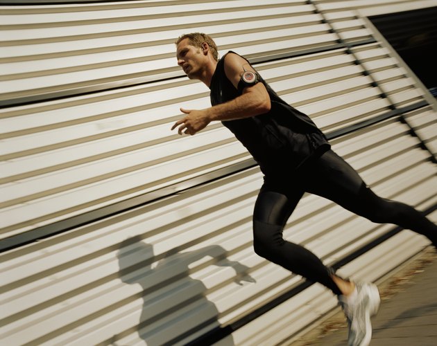 Man running past warehouse building (blurred motion)
