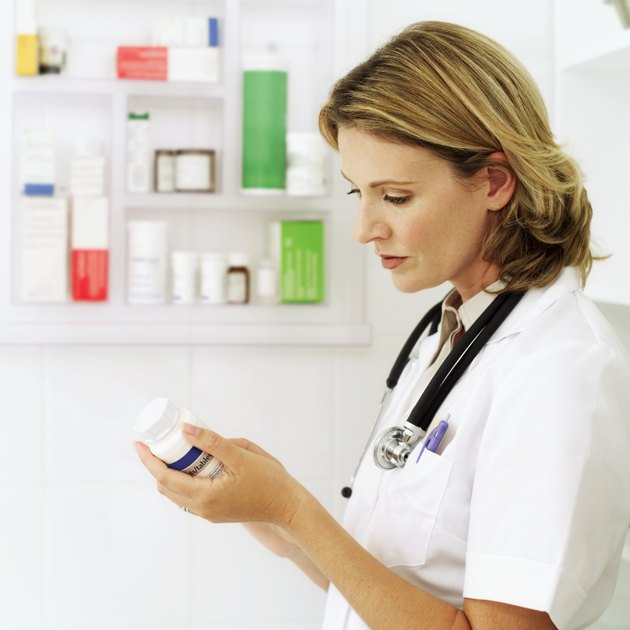 side view of a female doctor examining a bottle of medicine