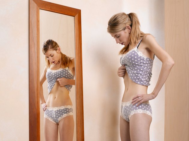 Young woman standing in front of mirror