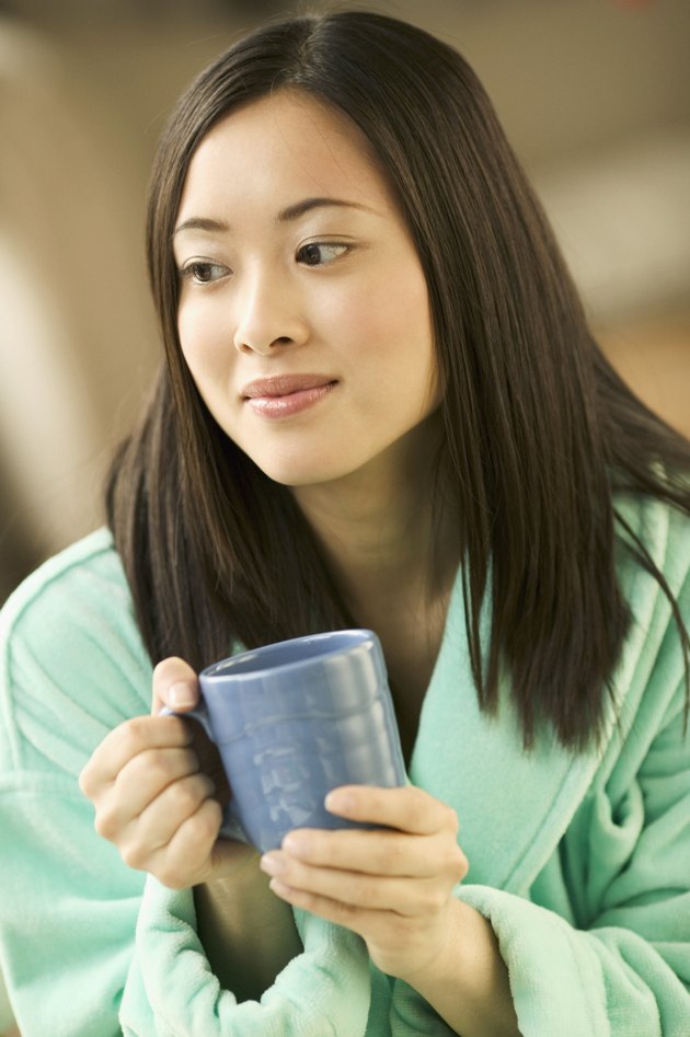 Young woman sitting holding a cup