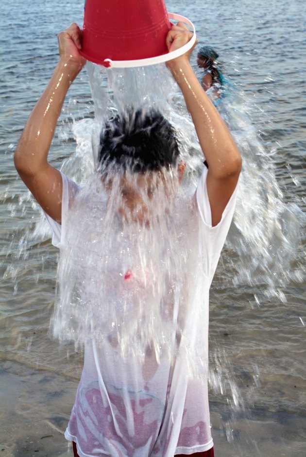 Child pouring a bucket of water over his head