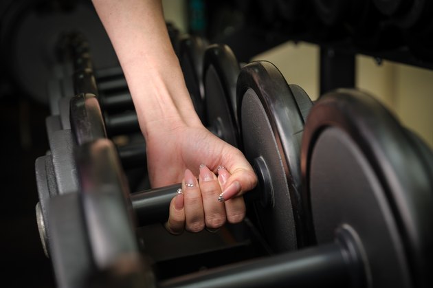 Female hand holding dumbbell