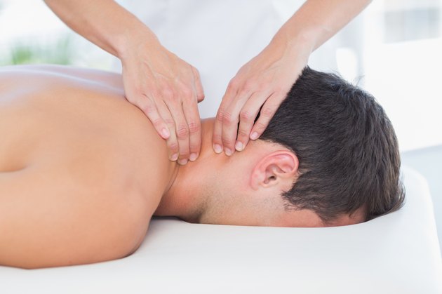 Physiotherapist doing neck massage to her patient
