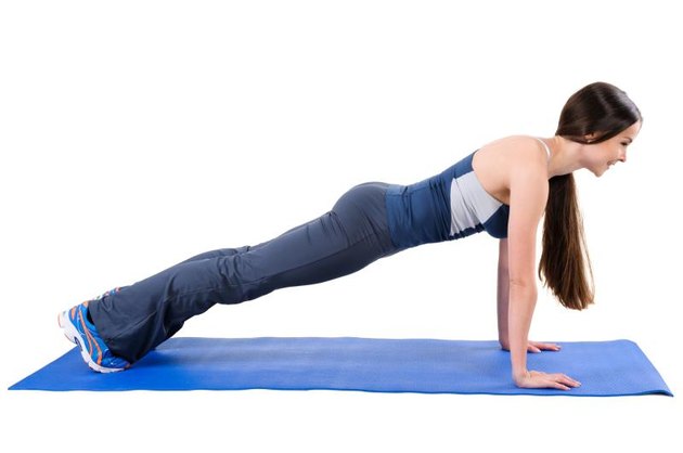 Young woman shows Straight Arms Plank Workout, isolated on white, side view