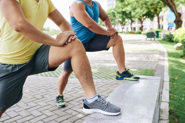 Cropped image of sporty people doing lunges in city park