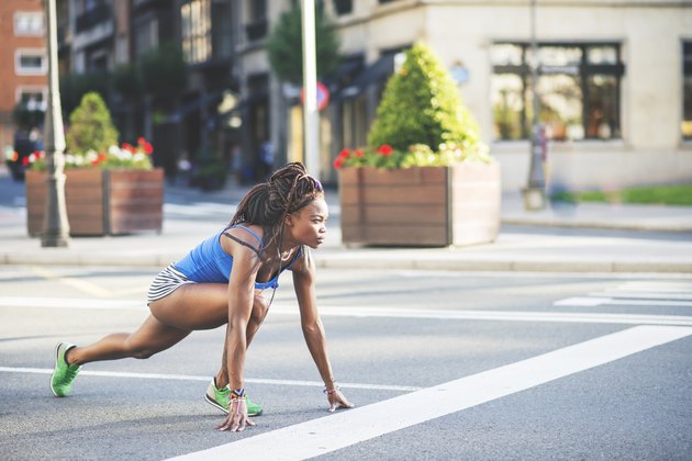 Beautiful african sport woman ready to run on the street.