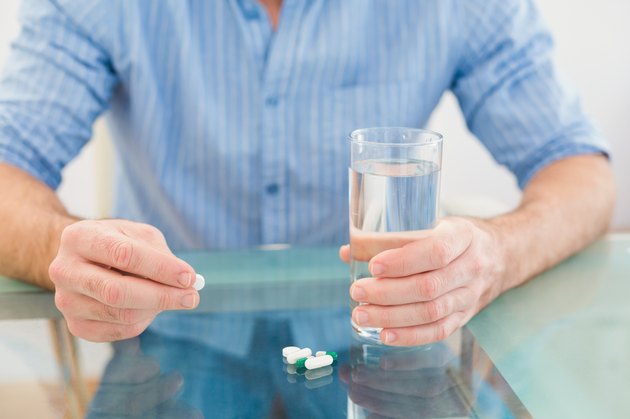 Casual businessman holding glass of water and tablet
