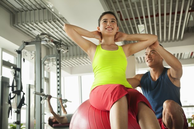Young women exercising with her personal trainer in the gym