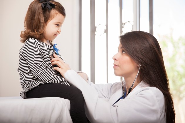 Pediatrician examining little girl