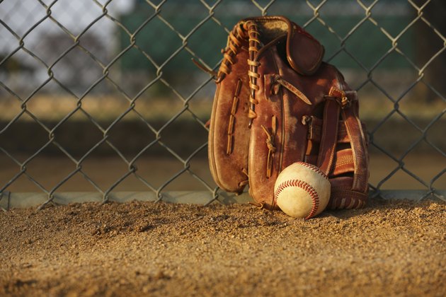 Baseball and Glove against the Fence