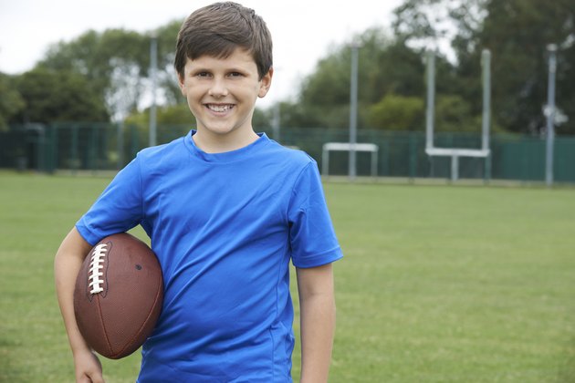 Portrait Of Boy Holding Ball On School Football Pitch