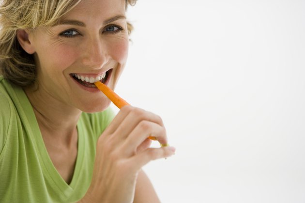 Woman eating carrot