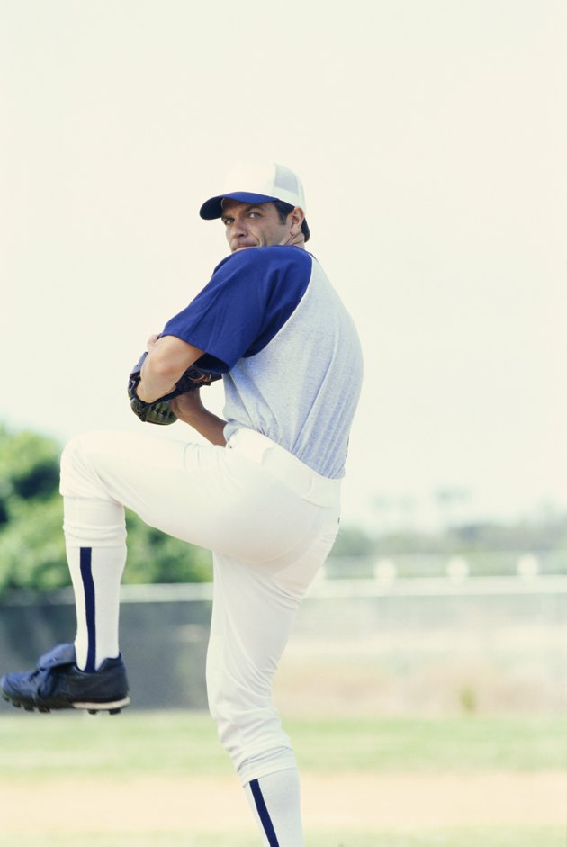 Baseball pitcher standing on one leg throwing ball