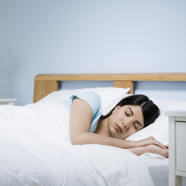 Mixed Race woman sleeping in bed
