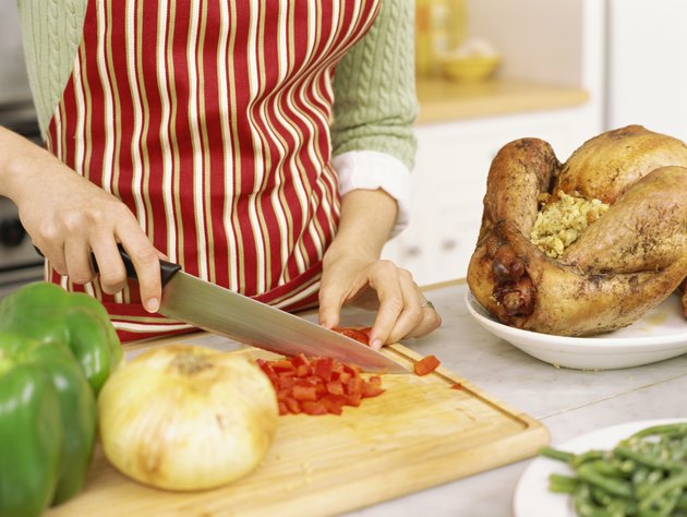 mid section view of a woman chopping tomatoes