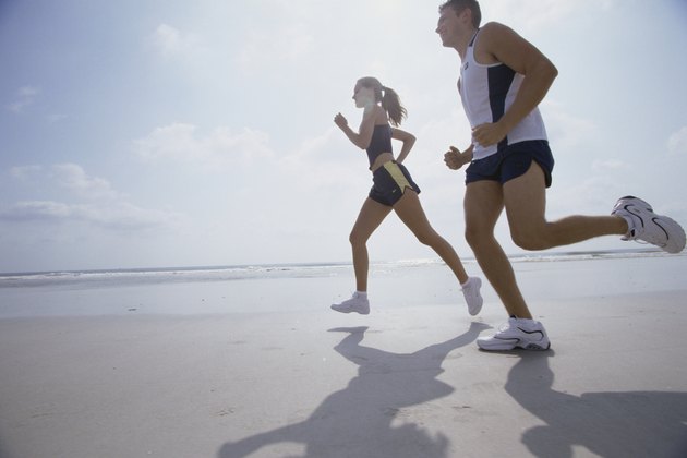 Low angle view of a young couple jogging on the beach