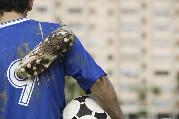 Soccer Player Carrying Muddy Shoes