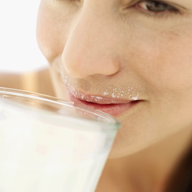 close-up of a young woman drinking a glass of milk
