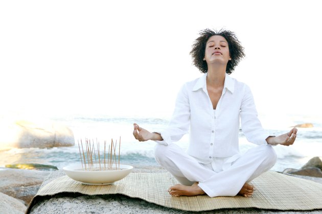 Woman meditating by ocean