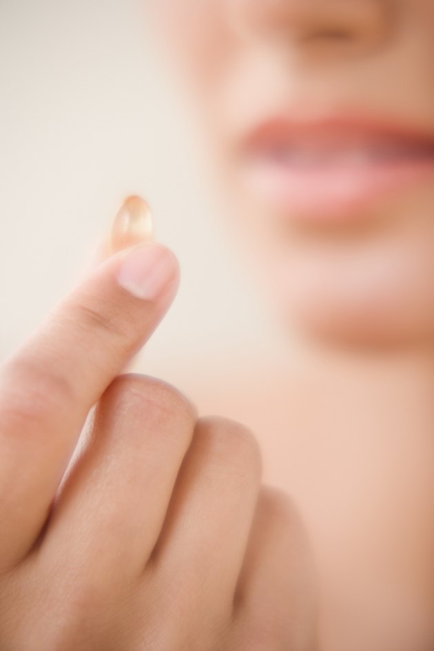 Close up of fingers holding vitamin