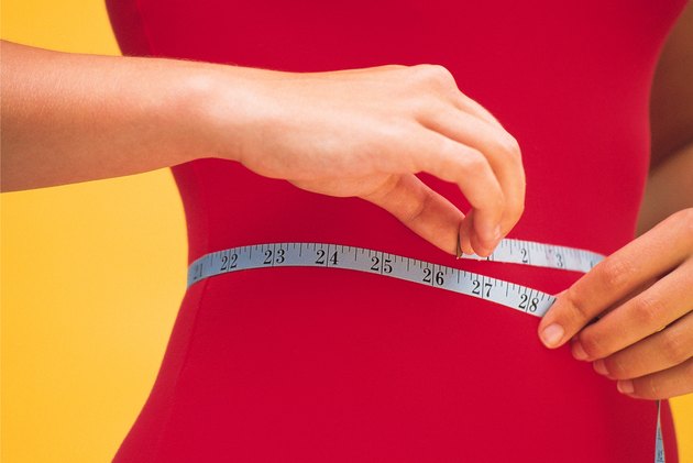 Woman measuring her waist