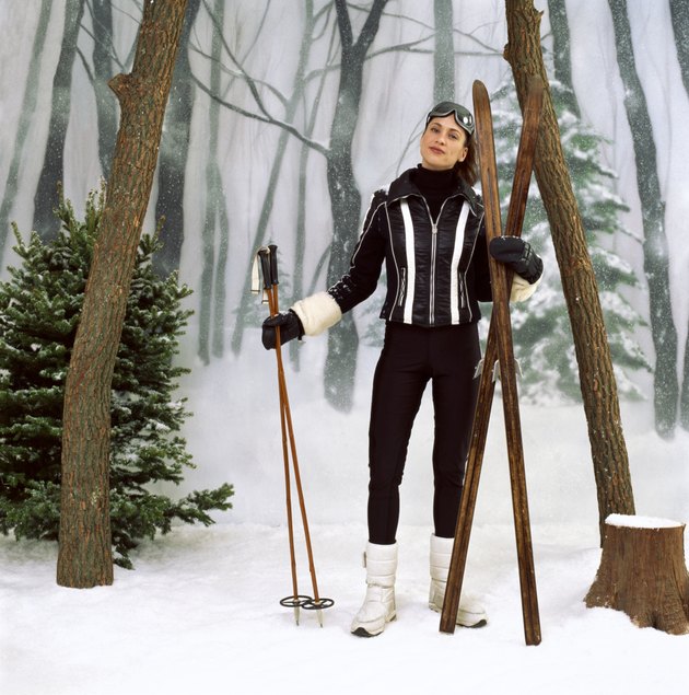 Woman with old skis and ski poles