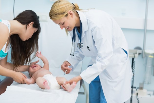 Mother and female doctor doing an injection on a crying newborn