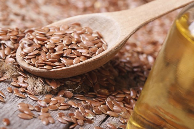 Flax seed in a spoon and oil. horizontal
