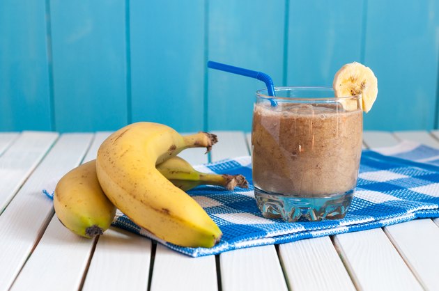 Healthy homemade banana juice in glass and fresh bananas on