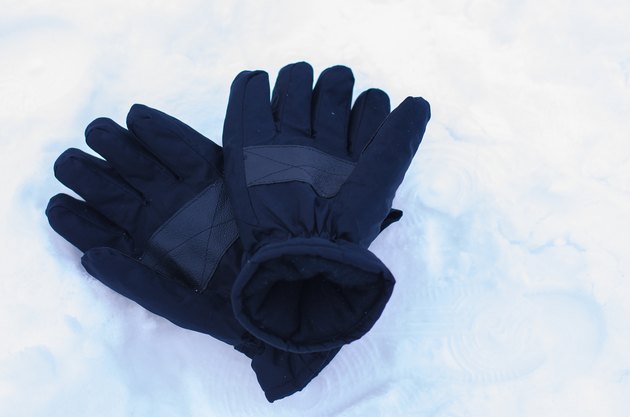 Snow gloves in winter season with snow background