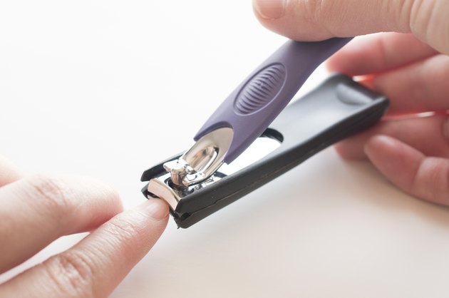 Close up of hand with nail clipper
