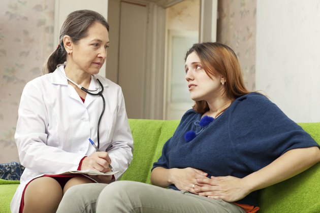 Woman complaining to doctor about stomachache