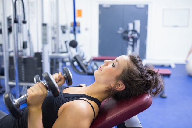 Concentrated woman lifting weights
