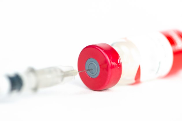 Injection preparation with vial and syringe on white