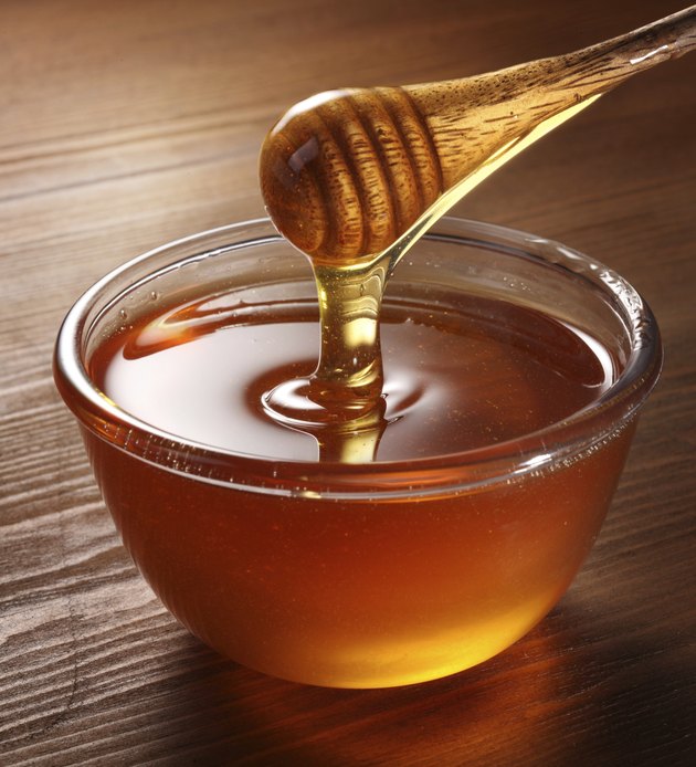 Honey pouring from drizzler into the bowl.