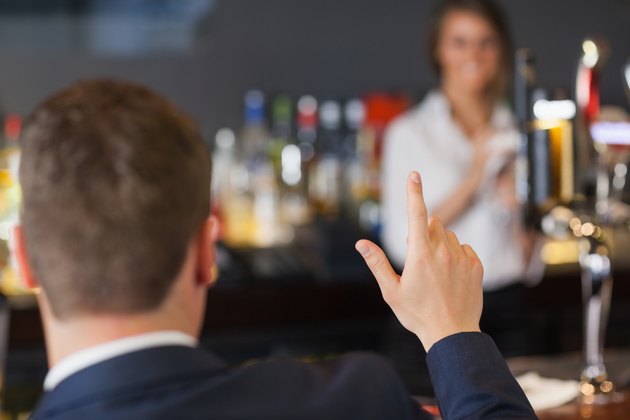 Handsome man ordering a drink from pretty waitress