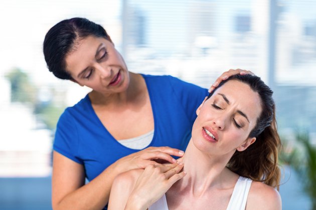 Therapist examining her patients neck